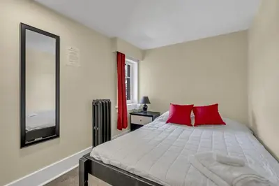 a bedroom with a bed with red pillows and a mirror at HI Penticton - Hostel in Penticton