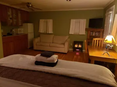 a bedroom with a bed and a living room at Riverbend Guest House in Chilliwack