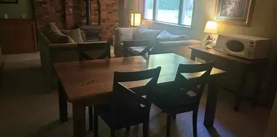 a living room with a wooden table and chairs at Riverbend Guest House in Chilliwack