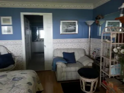 a living room with a couch and blue walls at Hammond Bay Oceanside Guesthouse in Nanaimo