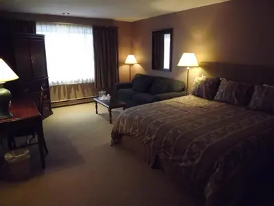 a hotel room with a bed and a couch at The Pacific Inn in Prince Rupert