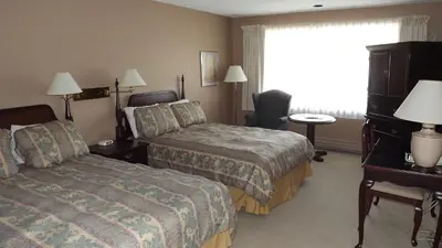 a hotel room with two beds and a window at The Pacific Inn in Prince Rupert