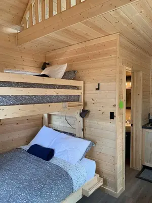 a bedroom with a bed in a wooden cabin at The Ranch Highway 55 in Debden