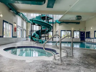 a swimming pool with a slide in a building at Super 8 by Wyndham High River AB in High River