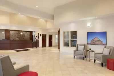a lobby with two chairs and a waiting room at Ramada by Wyndham Drayton Valley in Drayton Valley