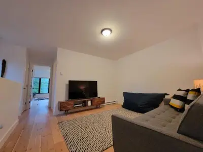 a living room with a couch and a flat screen tv at Reef Point Cottages in Ucluelet