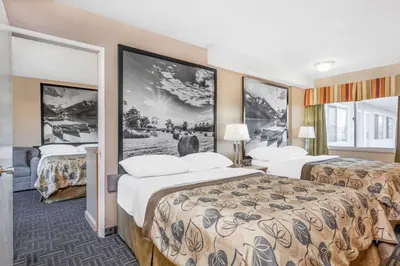 a hotel room with two beds and posters on the wall at Super 8 by Wyndham Stettler in Stettler