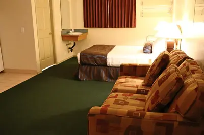 a hotel room with a bed and a couch at SlumberLodge Hotel in Penticton