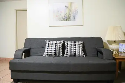 a gray couch with pillows on it in a living room at SlumberLodge Hotel in Penticton