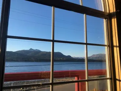 a window with a view of the water and mountains at Alert Bay Lodge in Alert Bay