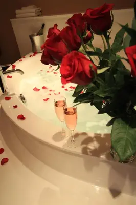 two wine glasses sitting on a table with roses at Century Casino & Hotel Edmonton in Edmonton