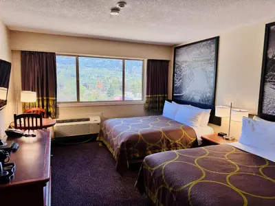a hotel room with two beds and a window at Super 8 by Wyndham Castlegar BC in Castlegar