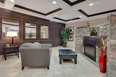 a living room with a couch and a fireplace at Ramada by Wyndham Stettler in Stettler