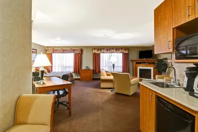 a room with a kitchen and a living room at Canalta Stettler in Stettler