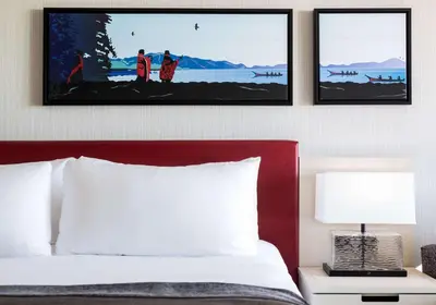 a bedroom with a bed with three pictures on the wall at Best Western Plus Tin Wis Resort in Tofino