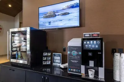 a hotel room with a tv on the wall and a coffee machine at Best Western Plus Tin Wis Resort in Tofino