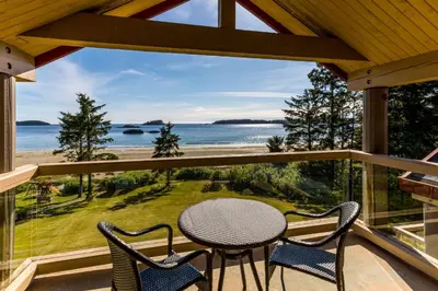 a table and chairs on a balcony with a view of the ocean at Best Western Plus Tin Wis Resort in Tofino
