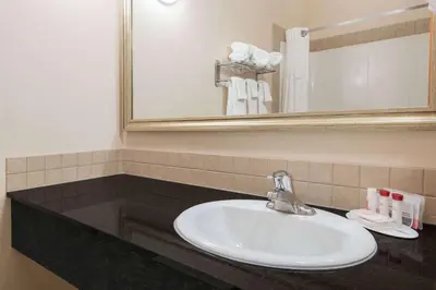 a bathroom with a sink and a mirror at Ramada by Wyndham Wainwright in Wainwright