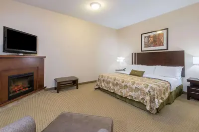 a hotel room with a bed and a fireplace at Ramada by Wyndham Wainwright in Wainwright