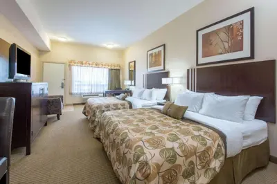 a hotel room with two beds and a television at Ramada by Wyndham Wainwright in Wainwright