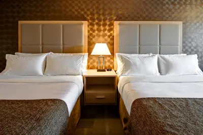 a hotel room with two beds and a table with a lamp at Canalta St.Paul in St. Paul