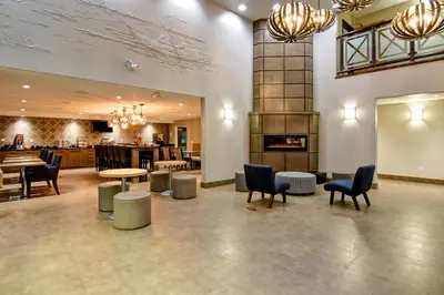 a lobby with chairs and tables and a fireplace at Canalta St.Paul in St. Paul