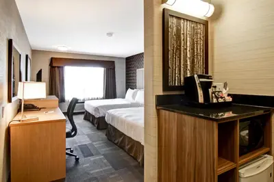 a hotel room with a bed and a desk with a television at Canalta St.Paul in St. Paul