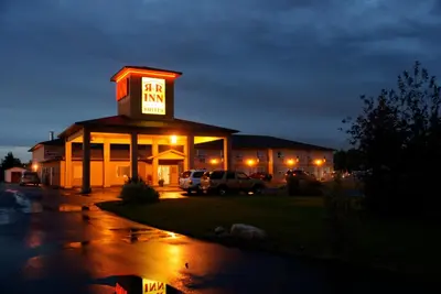 a building with a neon sign on top of it at R&R Inn & Suites in Camrose