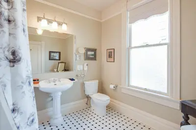 a bathroom with a toilet and a sink and a window at O Canada House Bed & Breakfast in Vancouver