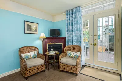 a living room with two chairs and a table and a tv at O Canada House Bed & Breakfast in Vancouver