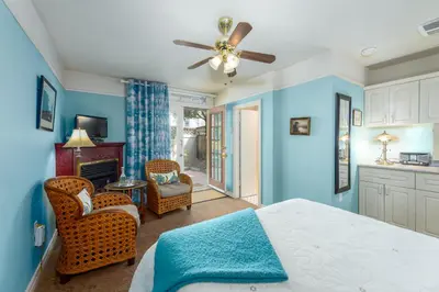 a bedroom with blue walls and a bed and chairs at O Canada House Bed & Breakfast in Vancouver
