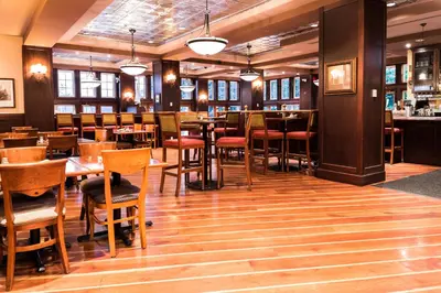 a restaurant with wooden floors and tables and chairs at Poets Cove Resort & Spa in Bedwell Harbour