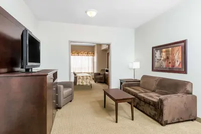 a living room with a couch and a flat screen tv at Ramada by Wyndham Olds in Olds