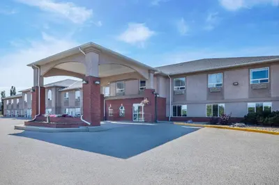 a large building with an archway in a parking lot at Clarion Pointe in Rimbey