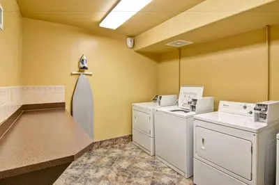a laundry room with washers and dryers in a room at Ramada by Wyndham Ponoka in Ponoka