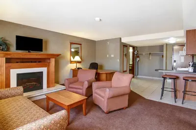 a living room with a couch and a fireplace at Ramada by Wyndham Ponoka in Ponoka