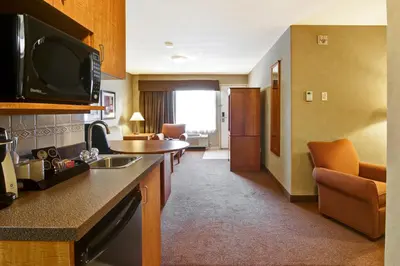 a hotel room with a kitchen and a living room at Ramada by Wyndham Ponoka in Ponoka