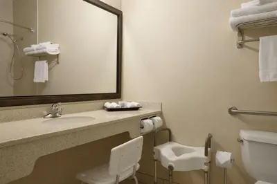 a bathroom with a sink and a toilet and a mirror at Travelodge by Wyndham Strathmore in Strathmore