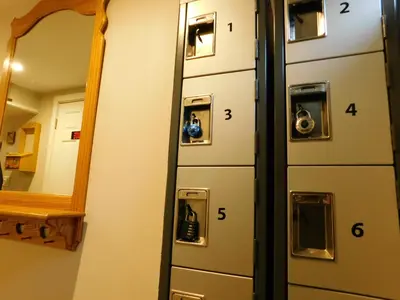 a row of lockers in a room with a mirror at The Calgary Hub hostel style Home in Calgary