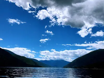 a view of a lake with mountains and clouds at Kokanee Glacier Resort in Nelson