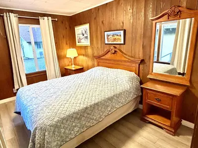 a bedroom with a bed and a mirror at Richca Chalets Resort in Hope