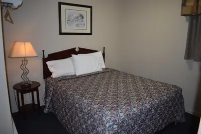 a hotel room with a bed and a lamp at Hope Inn and Suites in Hope