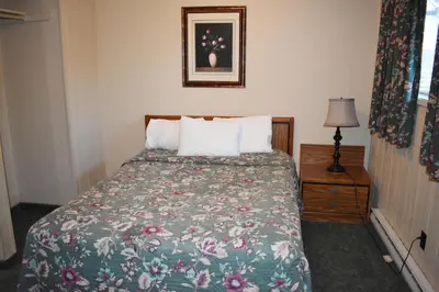 a bedroom with a bed with a floral bedspread at Hope Inn and Suites in Hope