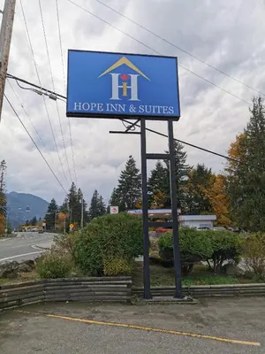 a sign for a hope inn and suites on the side of a road at Hope Inn and Suites in Hope