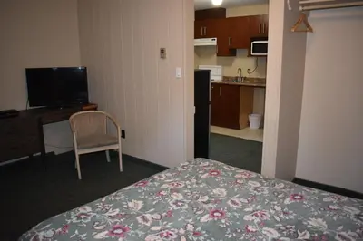a room with a bed and a desk and a kitchen at Hope Inn and Suites in Hope