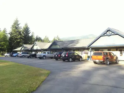 a parking lot with cars parked in front of a building at New Horizon Motel in Christina Lake