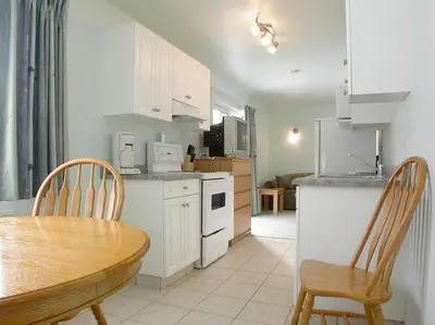 a kitchen with a table and chairs and a dining room at New Horizon Motel in Christina Lake