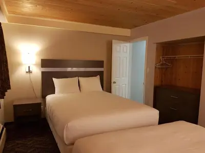 a hotel room with two beds and a closet at Holiday Motel & RV Resort in Hope