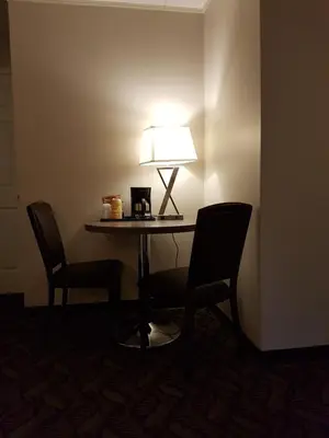 a table with two chairs and a lamp on it at Holiday Motel & RV Resort in Hope