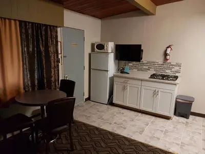 a small kitchen with a table and a refrigerator at Holiday Motel & RV Resort in Hope